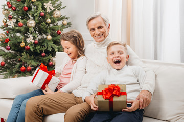 grandfather and kids with christmas gifts