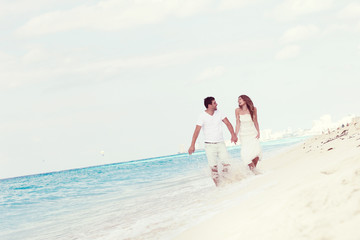 Young  beautiful newlyweds on white sandy beach