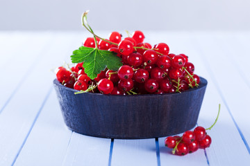 Ripe red currant in wooden bowl