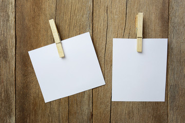 Notepad with a wooden clamp on wood background.