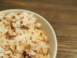 Thai local Jasmine white and red brown boiled rice in ceramic bowl, on wooden table, close up