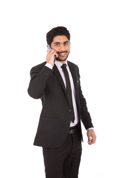 Happy handsome young businessman smiling and making a call, guy wearing black suit and black tie, isolated on white background