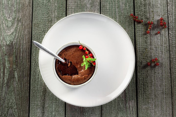 Tasty chocolate mousse on a rustic wooden table. Delicious dessert with liquid chocolate inside....
