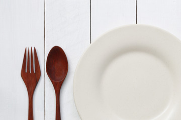 Plate and spoon on white wood floor.