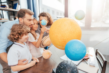 young happy family making solar system model for school project © LIGHTFIELD STUDIOS