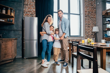 adorable young family embracing on kitchen