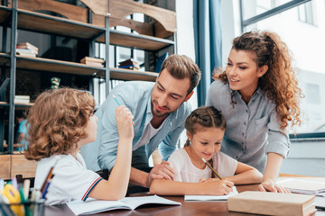 parents doing homework with cute happy kids