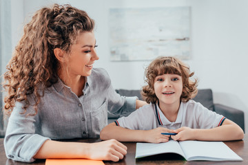 young mother and funny son doing homework together