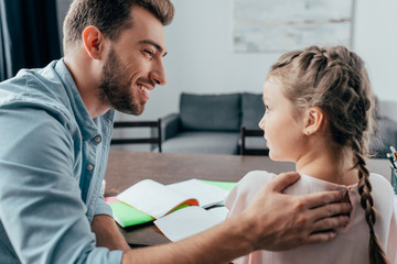 Fototapeta premium young handsome father helping her daughter with homework