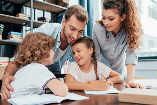 Beautiful Young Parents Doing Homework With Kids