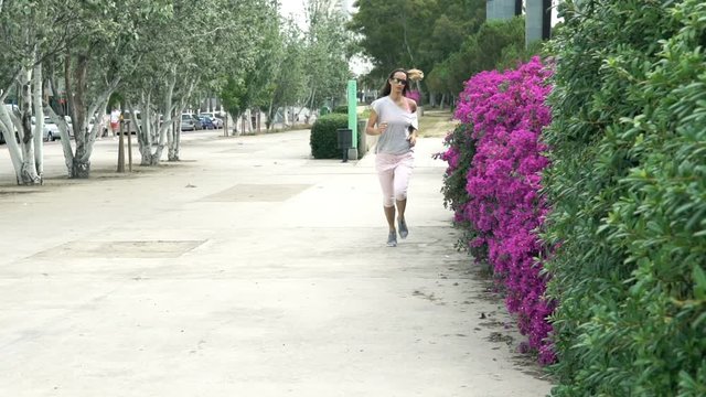 Young woman jogging in city park, super slow motion 120fps
