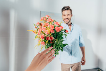 handsome man giving bouquet to his girlfriend