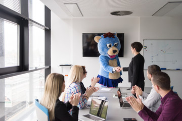 boss dresed as bear having fun with business people in trendy office