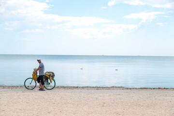 Fototapeta premium Seller of fish sells fish on the beach by bike