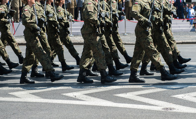 Żołnierze maszerują na drodze asfaltowej - obrazy, fototapety, plakaty