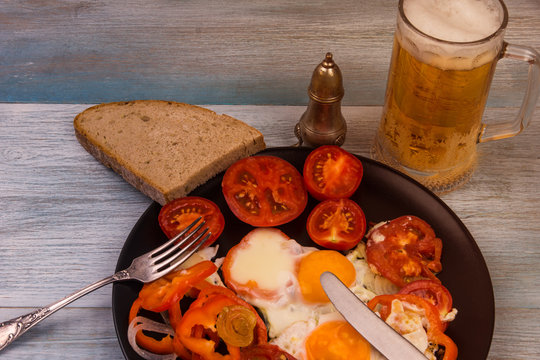 Beer and rustic eggs with tomatoes