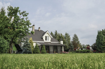 private house and its garden under beautiful sky