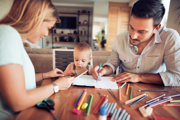 Young parent drawing with their little son
