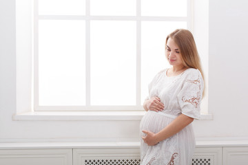 Pensive pregnant woman dreaming about child