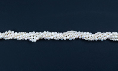 White pearl necklace on the dark background