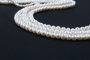 White pearl necklace on the dark background