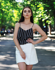 Naklejka premium Young girl model posing at the park looking at the camera from up