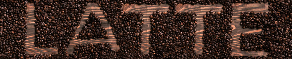 Latte word written with wooden letters on coffee beans heap