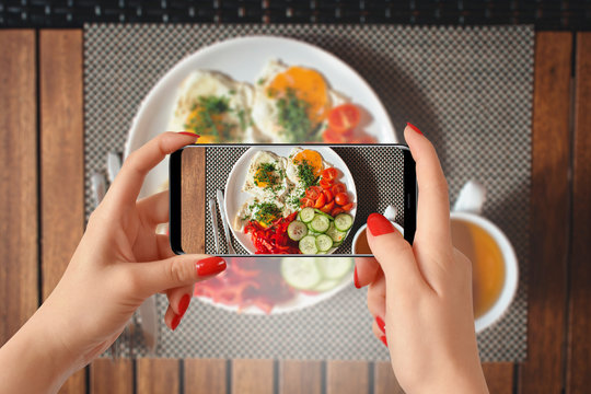 Woman hands taking photo of breakfast with smartphone
