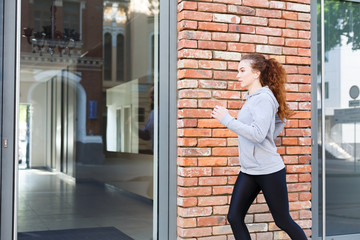 Young woman running in city copy space