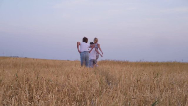 Mother and sons walking in wheat field
