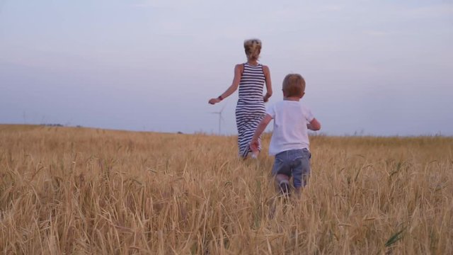 Mother and son walking in wheat field