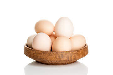 chicken eggs in a wooden plate isolated on white background