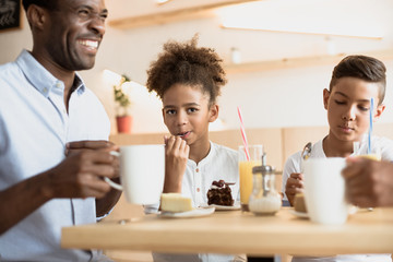 adorable african-american father and kids in cafe