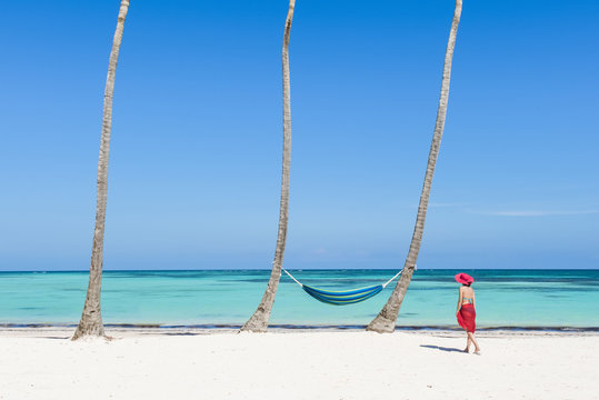 Juanillo Beach (playa Juanillo), Punta Cana, Dominican Republic. Woman walking on a palm-fringed beach (MR).