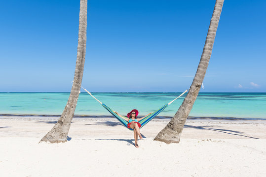 Juanillo Beach (playa Juanillo), Punta Cana, Dominican Republic. Woman relaxing on a hammock on the beach (MR).