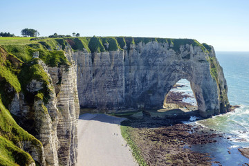 France, Normandy (Normandie), Seine-Maritime department, Etretat. White chalk cliffs and Aiguille d'Etretat, natural stone arch on the coast.