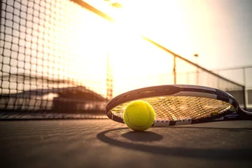 Foto op Canvas Tennis ball and racket on hard court under sunlight © icedmocha