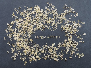Guten Appetit - Buchstabennudeln auf schwarzer Steinplatte - obrazy, fototapety, plakaty