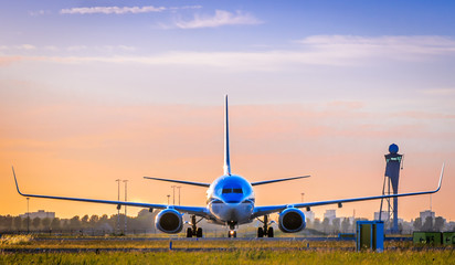 Front view of airplane at sunset, taken in Schiphol Airport, Netherlands - obrazy, fototapety, plakaty