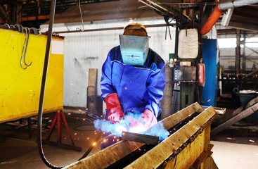 Fototapeta premium Welder for his work. Welding sparks on production background