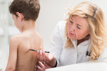 Physical therapist examining posture of a little boy