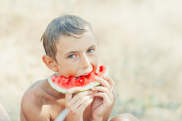 Little boy on holiday eating watermelon