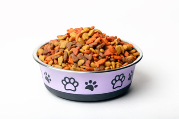 Colorful dry pet cat dog food in granules in cute bowl isolated on white background.