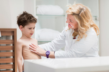 Physical therapist doing medical exam with little boy