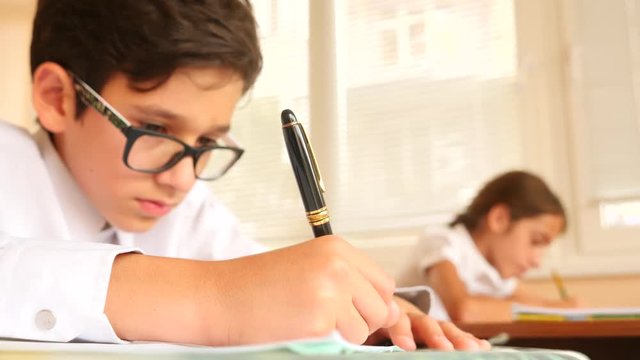 education, people and learning concept - group of students with notebooks writing test at school. 4k. Slow motion