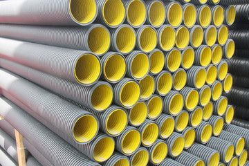 Stack of black  yellow corrugated plastic pipes