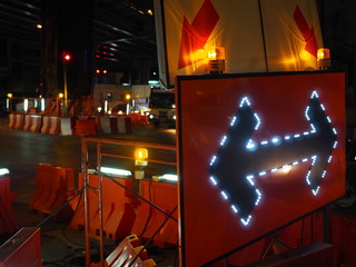Two way arrow traffic sign with lighting on dark night road