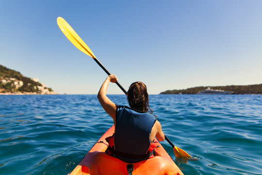 Girl is kayaking on the adriatic sea