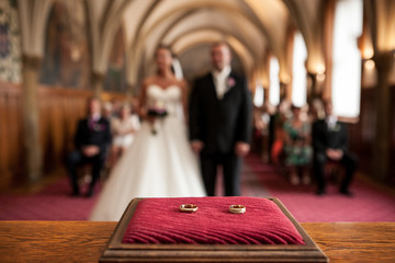 Wedding rings in front of bride and groom