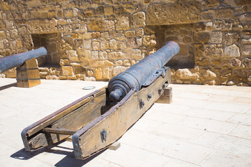 Antique cannons in the castle. Large heavy guns. Old medieval black iron cannon. Vintage Weapons.